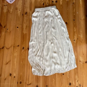 Krämvit långkjol  - Supersnygg krämvit långkjol från Gina tricot. Kjolen har resår i midjan. Storlek XS. Varan har lite täcken på användning. Längs ner är sömarna lite slitna och tyget har lite strådar som sticker upp (se bild 4 och 5). KAN ABSOLUT GÅ NER I PRIS VID SNABB AFFÄR ELLER BUNDLE!