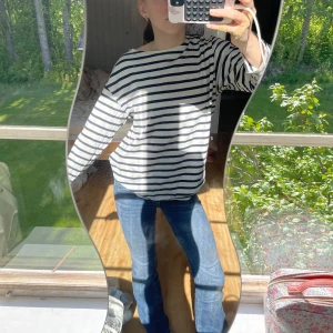 Randig långärmad tröja Latitude Marine - Säljer en klassisk långärmad tröja från Latitude Marine i marinblått och vitt. Tröjan har breda horisontella ränder och en avslappnad passform med rund hals. Perfekt för en chill och stilren look.