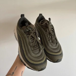 Nike Air Max 97 i olivgrönt - Nike Air Max 97 sneakers i olivgrön färg. Defekterna syns på bilderna men skorna håller mycket fint skick storlek 37,5 och innersulan är 23,5 cm. 👍🏽