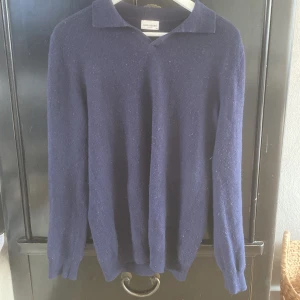 Mörkblå ulltröja från John Henric - Klassisk mörkblå tröja från John Henric i 90% ull och 10% kashmir. Tröjan har krage. Perfekt för dig som gillar stilren och tidlös design med en mjuk och skön känsla. Storlek M