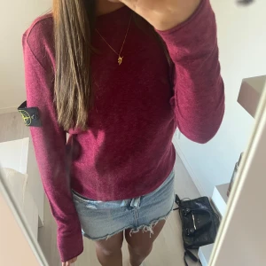 Vinröd Stone Island tröja i bomull - Säljer en vinröd långärmad tröja från Stone Island i mjuk bomull. Tröjan har klassisk rund hals, ribbade muddar och den ikoniska Stone Island-loggan på ärmen. Perfekt för dig som gillar streetwear och vill ha en snygg basic i garderoben. Sjukt snygg i storlek s ny