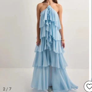 Klänning Vero Moda - Superfin ljusblå långklänning från Vero Moda med volanger i flera lager och smala axelband. Klänningen heter VMFelicia på vero Moda. Använd en gång på balen. 