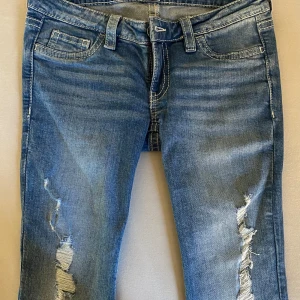 Blå bootcut jeans med slitningar - Säljer ett par blåa lowwaist bootcut jeans med slitningar ifrån Gina tricot. Jeansen är endast testade och är därför helt som nya! (Finns alltså INGA defekter eller fel). På bakfickorna finns mönster samt en knapp att stänga med. Strl M. Säljer på grund av att de tyvärr är för stora för mig. Hör gärna av er vid frågor eller funderingar! Är öppen för prisförslag!💞💕 