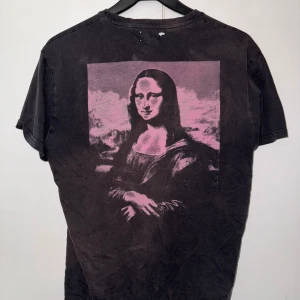 Mona Lisa T-shirt - Mona Lisa T-shirt i svart och Lila storlek S i modell, det är möjligt att kunna köpa min andra Mona Lisa T-shirt tillsammans med ett bra pris   Den är lite sönder där bak som på bilden men annars är den super skön och fin!
