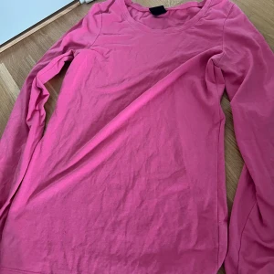 Rosa långärmad tröja från Cubus - En enkel och snygg rosa långärmad tröja från Cubus i mjuk bomull. Modellen har rund halsringning och en klassisk passform som funkar till allt. Perfekt att styla med jeans eller kjol för en chill look.