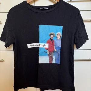 Svart t-shirt med retrotryck från Zara, storlek S - Svart t-shirt från Zara Trafaluc med retrotryck framtill. Klassisk passform och rund hals. Gjord i mjuk bomull. Storlek S