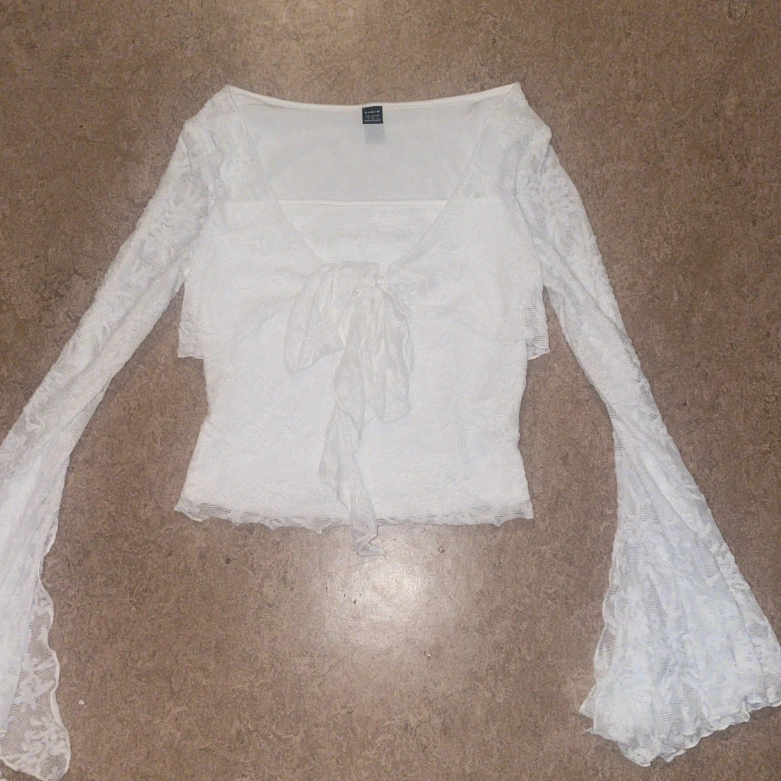 Vit spetsblus med knut.