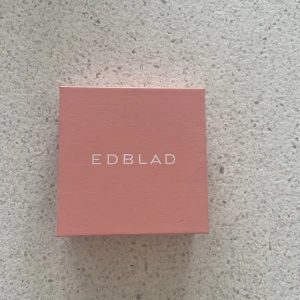 Guldiga örhängen från Edblad - Snygga guldiga örhängen från Edblad med minimalistisk design. Örhängena är små hoops med en spetsig konformad detalj som hänger ner. Perfekta för dig som gillar stilrena smycken med en edgy twist. Levereras i original ask.