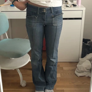 Blå lågmidjade jeans - Snygga blå jeans med bootcut-modell, från Nelly. Perfekta för en trendig och avslappnad look😊Storlek 34 & Inga defekter!!