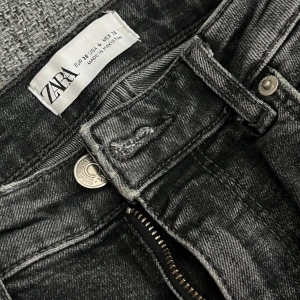 Svarta raka högmidjade jeans från Zara, strl 36 - Knappt använt. Säljer ett par svarta jeans från Zara i storlek 36. De är högmidjade med raka/utsvängda ben. Jeansen är stretchiga.