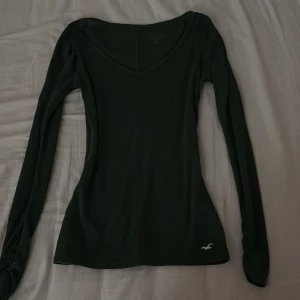 Mörkgrön långärmad tröja Hollister - Säljer en mörkgrön långärmad tröja från Hollister med v- ringning. Köpt ifrån Vinted tror jag:)