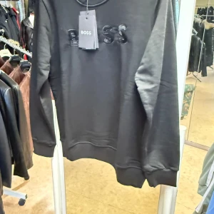 BOSS sweatshirt i svart och grått - Två stilrena sweatshirts från BOSS, en i svart och en i ljusgrå. Båda har broderad BOSS-logga framtill, rund halsringning och långa ärmar. Perfekt för dig som gillar enkel men snygg design. Materialet känns mjukt och skönt mot huden.