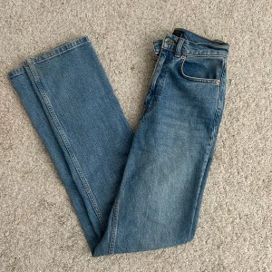 Jeans - jeans med rak passform och hög midja. Jeansen har fem fickor, knappgylf och är tillverkade i robust denim. Perfekta för en avslappnad och tidlös stil.