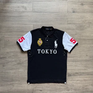 Svart och vit Polo Ralph Lauren Tokyo tee - ***INTE MIN BILD*** Klassisk svart och vit polo asfet och perfekt condition inget slitage alls. Size M men sitter som en small. Min kamera är kass men kan skicka bilder om du vill ha. Skriv om du har frågor