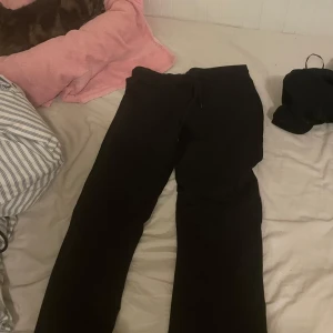 Svarta mjukisbyxor med snörning - Svarta mjukisbyxor med skön passform och snörning i midjan. Perfekta för chill dagar eller när du bara vill vara bekväm. Klassisk rak modell som funkar till det mesta.