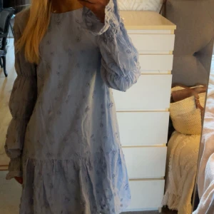 Ljusblå klänning från NAKD - Säljer denna supersöta trendiga ljusblåa klänningen med blommor från nakd!! Aldrig använd, prislapp kvar - därav som ny! 😇