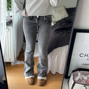 Grå bootcut jeans från Gina Tricot - Säljer ett par grå jeans från Gina Tricot i storlek 164. Jeansen har bootcut-modell med lätt utsvängda ben och klassisk femficksdesign. Snygg tvättad grå färg och tillverkade i mjukt jeanstyg. Perfekta för en chill och trendig look. Jag är 164 som referens! 💖