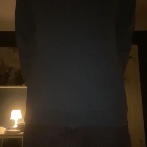 Blå hoodie från Lyle & Scott - Snygg blå hoodie från Lyle & Scott med klassisk gul logga på bröstet. Tröjan har huva, magficka och långa ärmar. Perfekt för dig som gillar en enkel och stilren look. Tillverkad i mjuk bomull för skön känsla hela dagen.