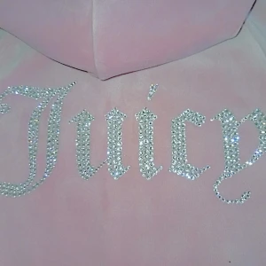 Juicy Couture rosa velourjacka XS, mkt fint skick - Säljer en fin rosa velourjacka från Juicy Couture (kan även tänka mig att BYTA mot en svart)  Använd väldigt få gånger så den är i mycket fint skick!! Jackan har glittrande strasstenar på ryggen med texten juicy, jc logga i stasstenar på bröstet, dragkedja med J-hänge och två fickor fram. Perfekt för dig som älskar 00-talsvibbar och vill sticka ut med bling. Den har inga fel eller svanker förutom att metal grejen saknas på snörningen, men det är inget man märker av.