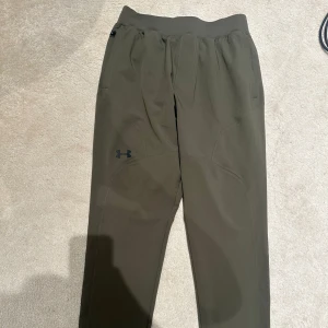 Gröna träningsbyxor Under Armour - Snygga gröna träningsbyxor från Under Armour. Dem är riktigt sköna och är i storlek M. Dem är i nytt skick då man bara använt dem cirka 1 till två gånger.