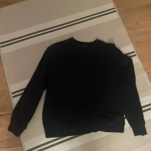 Svart basic tröja från Zara - Enkel svart tröja från Zara i storlek S. Tröjan har rund halsringning och långa ärmar med ribbade muddar. Perfekt för lager-på-lager och funkar till allt. Materialet är mjukt och känns skönt mot huden.