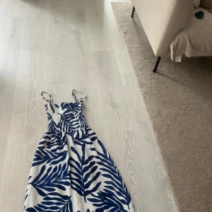 Blåvit sommarklänning med mönster i storlek XS - Supersöt blåvit klänning med smala axelband och smockad överdel🌺🌺Använt ca 1 gång. 