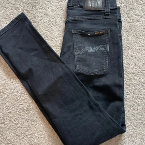 Nudie jeans  - Svarta jeans från Nudie Jeans med klassisk femficksdesign och ljusblå signatursöm på bakfickan. Jeansen är i riktigt bra skick. Storleken är 29/30. Priset är ej hugget i sten🤗