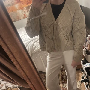 Beige stickad kofta från Zara - Säljer en mysig beige stickad kofta med knappar framtill. Koftan har ett fint mönster och långa ärmar, perfekt för kyligare dagar. Den är både stilren och bekväm, storlek M men jag tycker den passar XS/S då den är så kort samt sitter lite thightare😍😍Den är använd men i fint skick!
