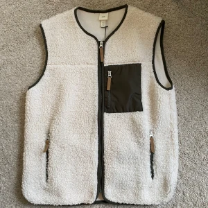 Vit fleeceväst från H&M - Supersnygg väst från H&M. Nästan aldrig använd så den är i så gott som nyskick! Säljer då den tyvärr var lite för stor för mig. Passar både dam och herr💓