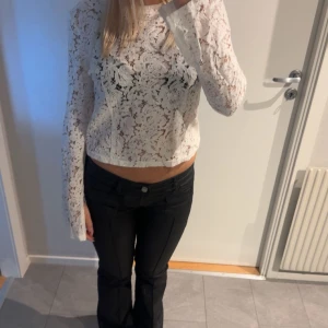 Vit spetsblus - Säljer en elegant vit spetsblus med långa ärmar. Blusen har en vacker spetsdesign som ger en romantisk känsla. Perfekt för att lyfta vilken outfit som helst.