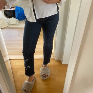 Mörkblå jeans med broderi - Snygga mörkblå jeans från Levi's med broderade detaljer på benen. De har en klassisk femficksdesign och en bekväm passform. Perfekta för en stilren look.