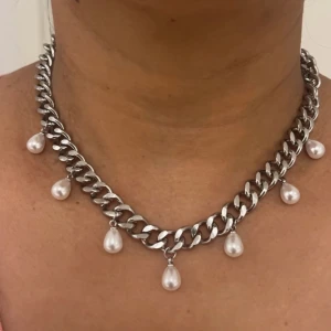 Silverfärgad halsband med pärlor  - Elegant halsband med hängande pärlor. Perfekt för att ge en lyxig touch till din outfit.