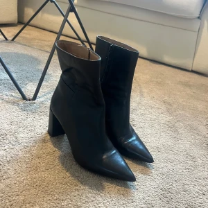 Svarta boots med klack - Snygga svarta boots i skinn med spetsig tå och klack. De har en dragkedja på sidan för enkel på- och avtagning. Supersköna att gå i. 7cm klack.