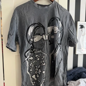 Grå t-shirt med tryck från Zara - Säljer en grå t-shirt från Zara med ett coolt tryck. T-shirten har korta ärmar. Den har en unik design med detaljer som ger en trendig look.🖤 säljer då den inte kommer till någon användning ❣️