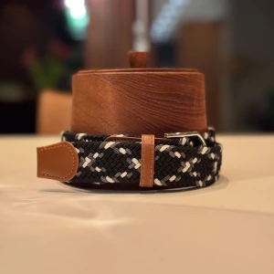 Svart och vitt flätat bälte - Helt nya flätade bälten i svart och vitt med bruna läderdetaljer och ett silverfärgat spänne. Perfekt för att ge en stilren touch till din outfit. Det finns 8 st i lager, så det är bara att höra av er ifall ni är intresserade!