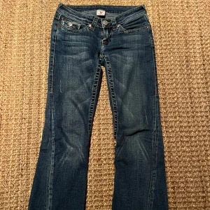 Blå jeans från True Religion - Jätte snygga blå jeans från True Religion med broderade detaljer på bakfickorna! De har en klassisk femficksdesign och är tillverkade i 100% bomull. Perfekta för en avslappnad stil med en touch av unik design!! ❣️❣️🥰🥰😍😍