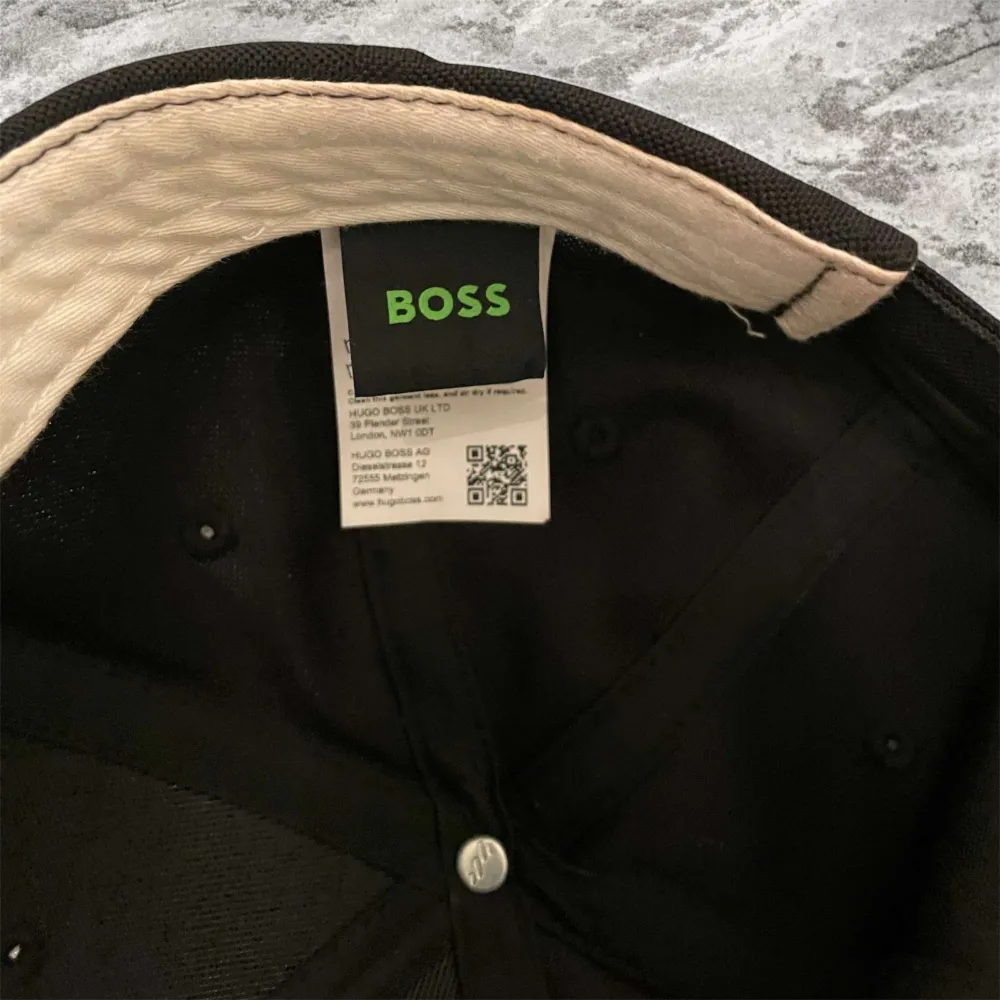 Snygg svart keps från BOSS med broderad logga framtill. Perfekt för en stilren look. Justerbar passform för optimal komfort.. Asusteet.
