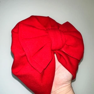 Röd turban med rosett - Snygg röd turban med en stor dekorativ rosett framtill. Perfekt för att ge en färgklick till din outfit. Tillverkad i ett mjukt och bekvämt material. 6mån - 1,5år.
