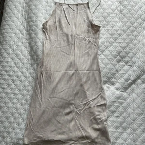 Beige ribbad klänning - Säljer en stilren beige ribbad klänning med smala axelband. Klänningen har en enkel och elegant design som passar perfekt för olika tillfällen. Den är tillverkad i ett mjukt och bekvämt material. Sätter sig superfint på kroppen!😍