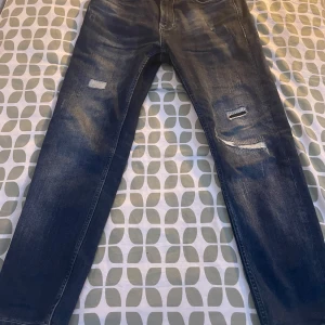 Mörkblå jeans med slitningar - Snygga mörkblå jeans från Dust Amp med coola slitningar på framsidan. De har en klassisk femficksdesign och en bekväm passform. Perfekta för en avslappnad stil.