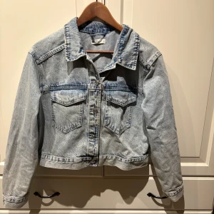 Ljusblå jeansjacka från Ginatricot - Säljer en klassisk ljusblå jeansjacka från Ginatricot i storlek M. Jackan har en rak passform med knappar framtill och två bröstfickor med lock. Perfekt för vår och sommar! Använd 1 gång så i mycket bra skick, inga defekter!💕