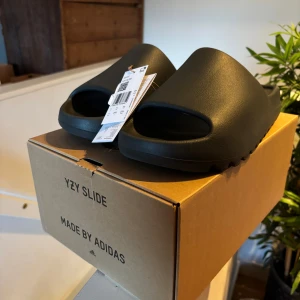 Yeezy slide  - Säljer att par yeezy slides Dark Onyx använda 1 gång stått i lådan sen dess, superbra skick!