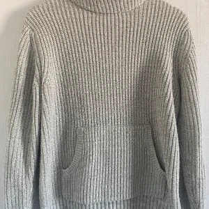 Grå stickad tröja från Lindex - Säljer en mysig grå stickad tröja från Lindex. Tröjan har en hög krage och en ficka framtill. Perfekt för kyliga dagar. Passar barn i åldern 10-12 år. 💕