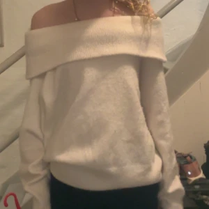 Vit offshoulder tröja - Säljer en stilren vit offshoulder tröja med långa ärmar. Tröjan har en bred krage som ger en elegant look. Perfekt för en avslappnad men chic stil. 