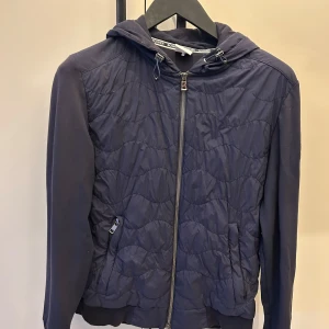 Mörkblå quiltad jacka med huva - Cardigan från Bogner med quiltad framsida och dragkedja. Perfekt vår/sommarjacka. Köpt i Bogners egna butik i Verbier,Schweiz 🇨🇭! Nypris: 535 Chf eller 6300kr.