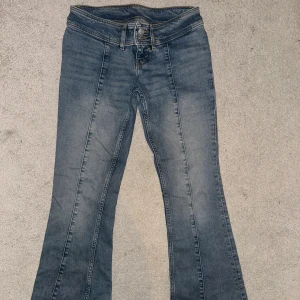 Blå bootcut jeans - Snygga trendiga monki jeansen! Säljer då de blivit för små för mig. De har tidigare varit sönder under skärpflärpen, vilket är lagat nu med symaskin. De är även en aning nedtrampade där bak men inget man tänker på enligt mig! Jag är 168 för referens ( jag är till höger på tredje bilden)! Midjemått ca 38cm🥰