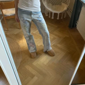 I'l Dolce jeans - Unika ljusblå jeans med coola broderade mönster i form av drakar och blommor. Byxorna har en straight passform och är perfekta för att ge din outfit en personlig touch.