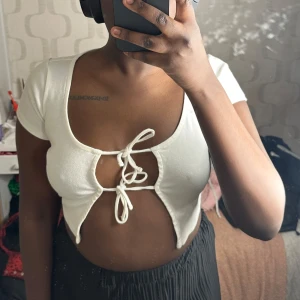 Vit croppad topp med knytning - Säljer en vit croppad topp med korta ärmar och knytning framtill. Perfekt för en sommarn med ett par jeans shorts!