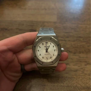 Silverfärgad klocka med länkarmband - Snygg klocka i silver med ett stilrent länkarmband och en rund urtavla. Klockan har en elegant design med tydliga markeringar och en robust boett.