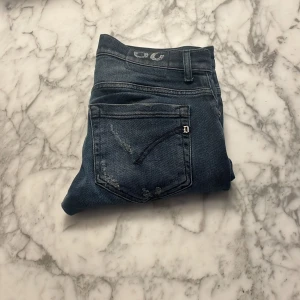 Dondup Blå jeans med slitningar - Snygga blå jeans från Dondup med coola slitningar för en trendig look. De har en klassisk femficksdesign och en knappgylf. Perfekta för en avslappnad stil.